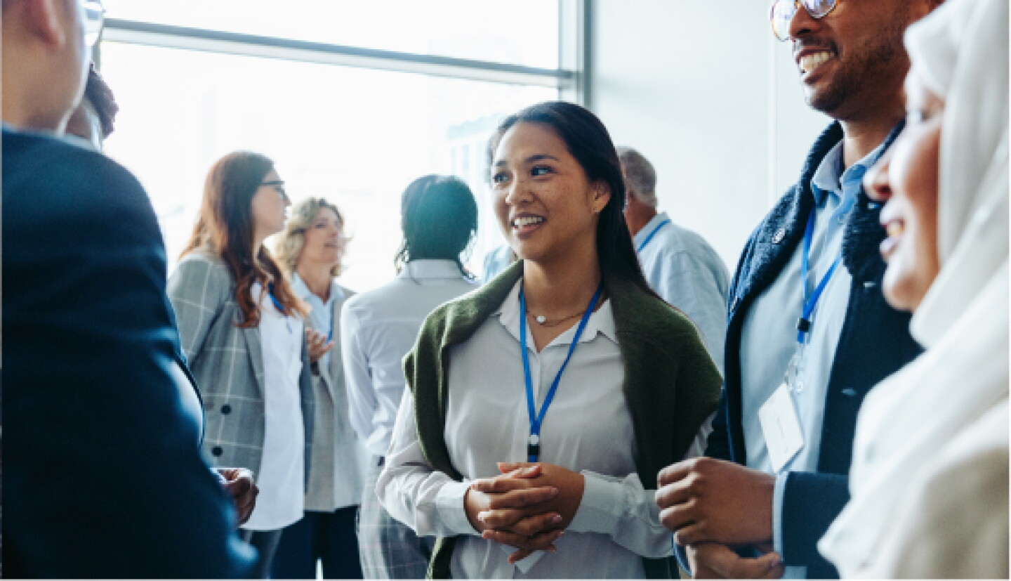 A female CWRU student conversing with attendees at a meet & greet event.