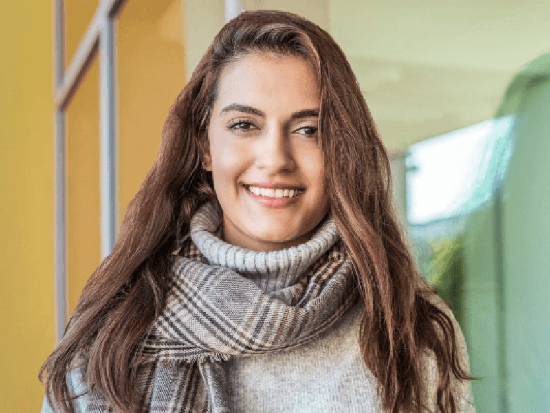 Woman with long hair wearing scarf and sweater