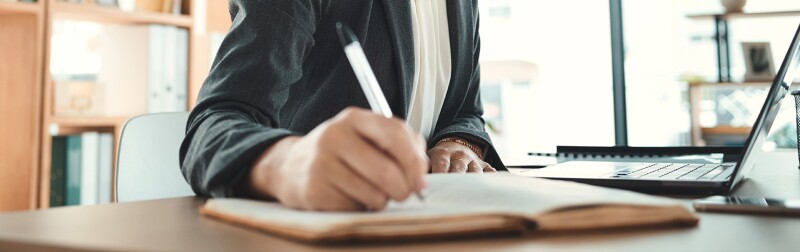 Close up a a woman writing in a notebook