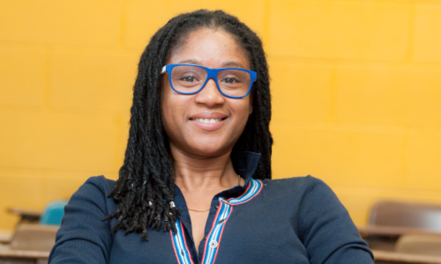 A female MSW student smiles while sitting at a desk.