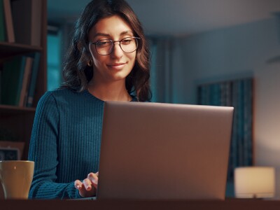 Young woman working with her laptop at night