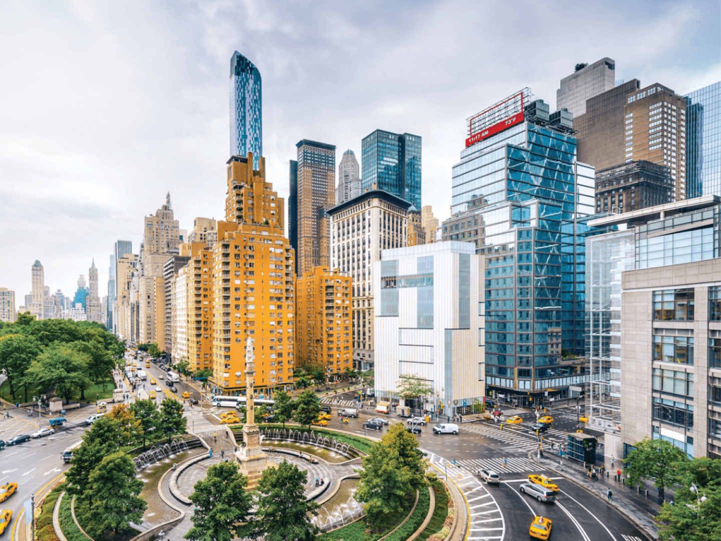 Columbus Circle in New York City with skyscrapers in the background and cabs on the street