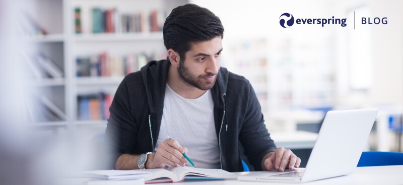 Man on computer writing notes