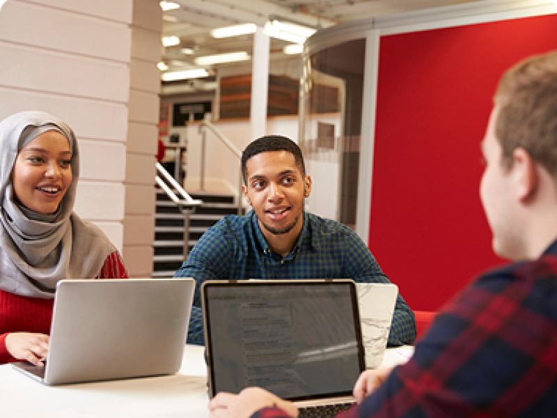 Three students working at their laptops