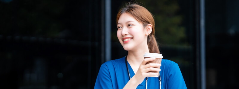 A nurse looks refreshed and happy after a break outdoors.