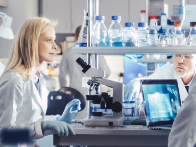 Group of Medical Researchers in White Coats are having a passionate discussion in a modern high-tech research laboratory.