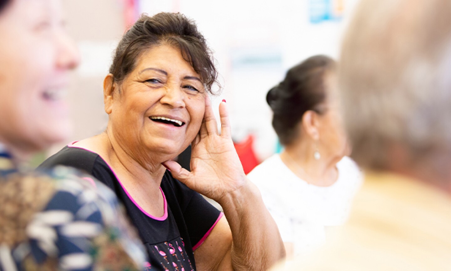 smiling older woman with face resting on hand