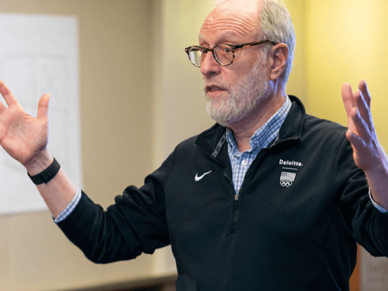 Man gesturing with both arms while speaking