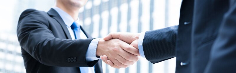 Two business professionals shaking hands, symbolizing a successful agreement or ethical partnership.