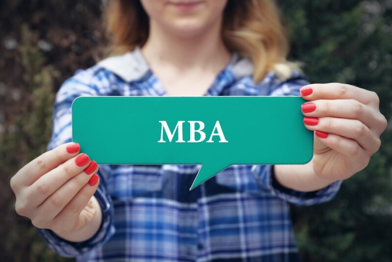 woman holding up an online mba program card