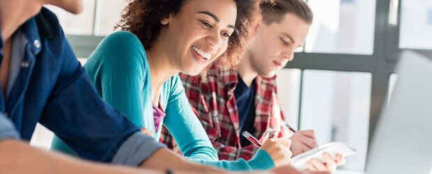 Man and woman taking notes in front of computer