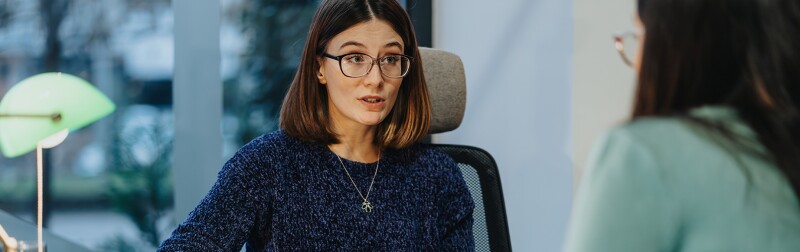 Professional women engaged in discussion with a recent graduate