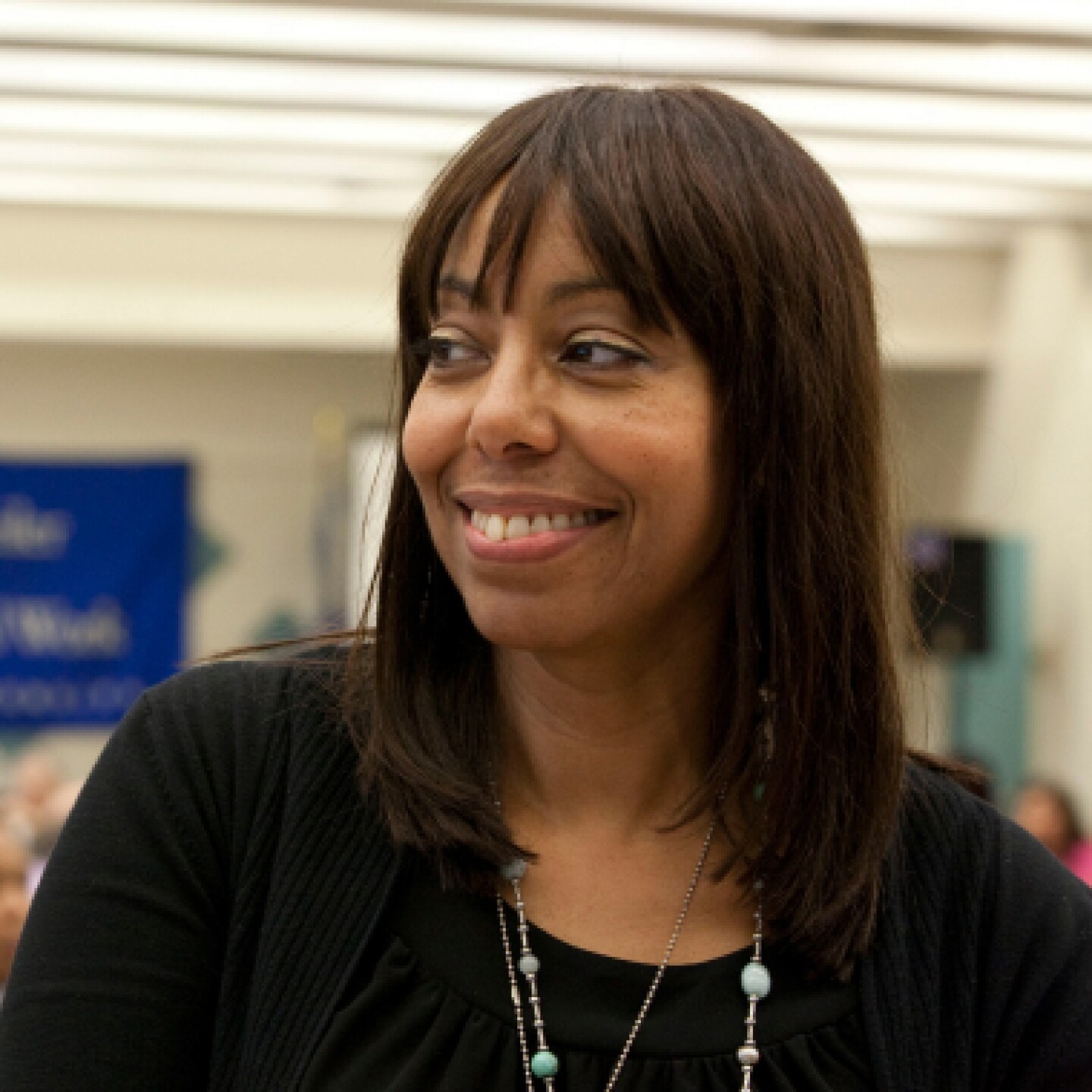 A close-up of a female student joyfully listening to fellow students talking.