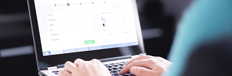 Person works on an online application portal on a laptop