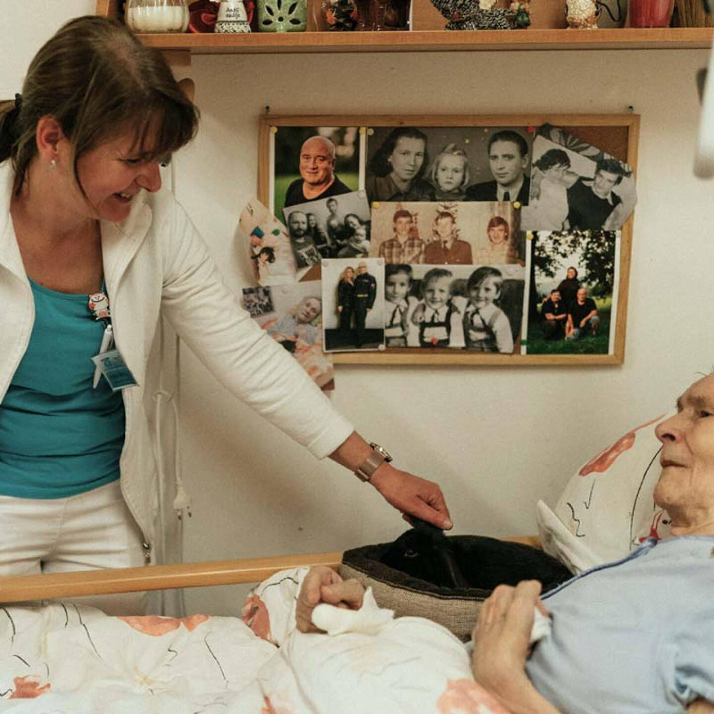 Geriatric nurse attending older patient in bed