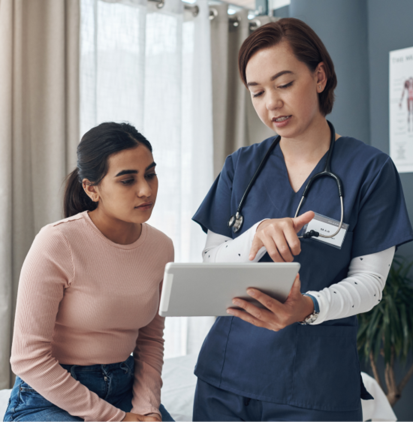 Uniformed nurse showing patient tablet screen