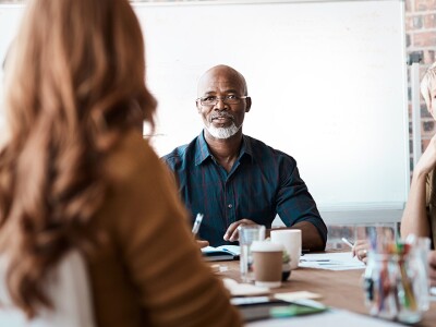 Group of five diverse people meeting in a boardroom