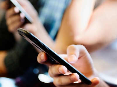 Group of young adult friends using smartphones in the subway