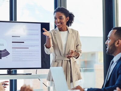 Marketing meeting, businesswoman and presentation on screen of tv in a boardroom with colleagues.
