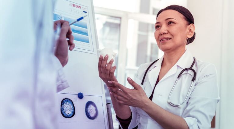 Female doctor describing charts on an easel