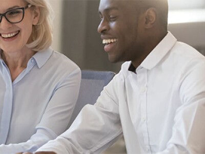 professional mentor sitting together focused on laptop