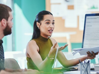 A meeting with a woman presenting customer data charts to her colleagues