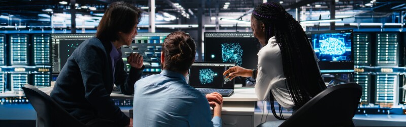 IT specialists working in data center, analyzing performance data using AI