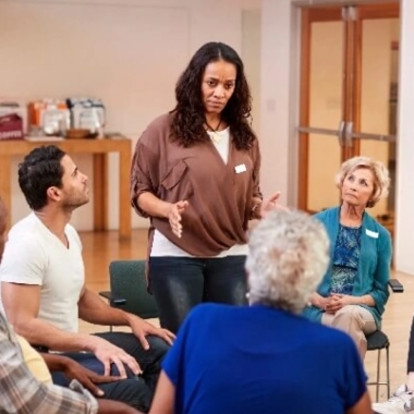 A Female substance abuse counselor stands to address her support group.