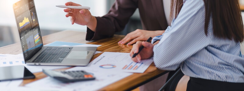 Two professionals analyzing business data on dashboard screen