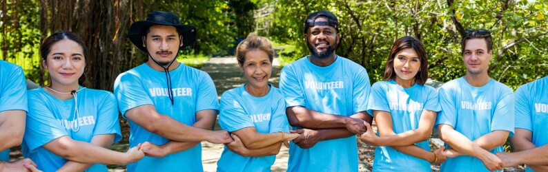 Volunteers holding hands in a chain facing the camera smiling