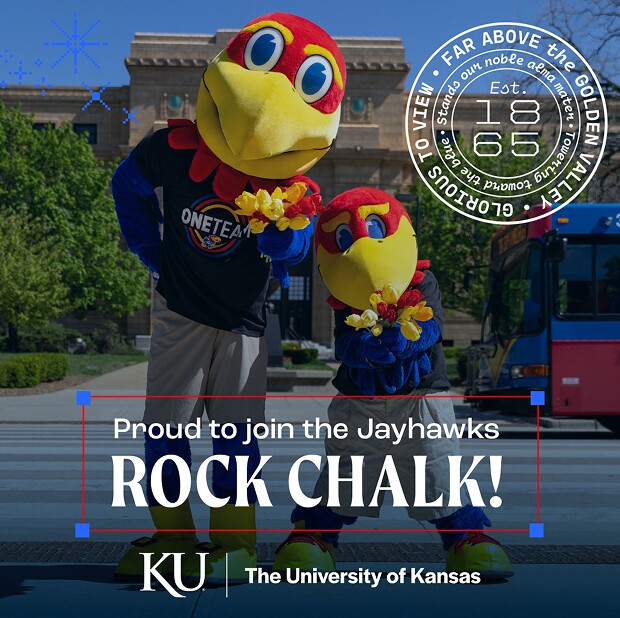 Two Kansas Jayhawks mascots posing together on campus in front of a building and street.
