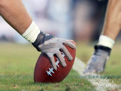 American football players lined up, ready to snap the ball.