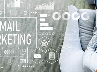 Overhead view of seated person using a laptop, next to a graphic that says "Email Marketing"