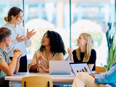 Business professional leads a collaborative meeting in a sunlit office