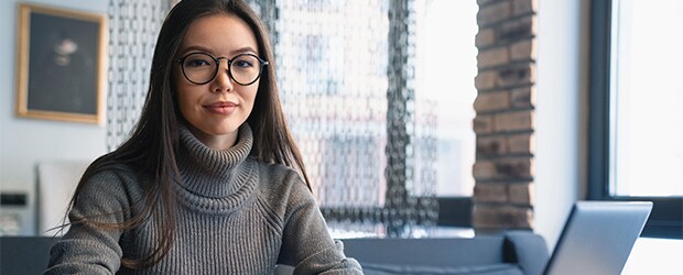 Confident student studying on laptop at cafe