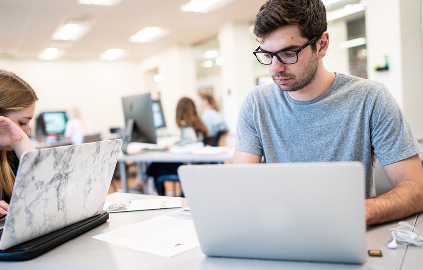 Two student working on their laptops