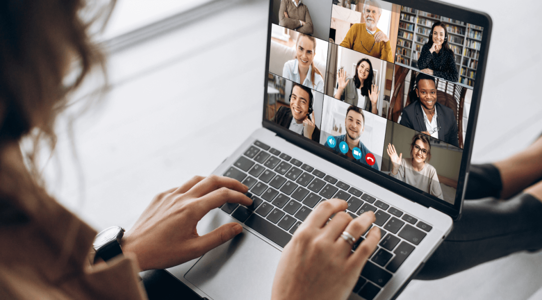Woman looking at laptop screen displaying meeting room participants