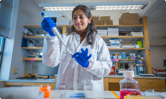 woman with white coat and blue gloves