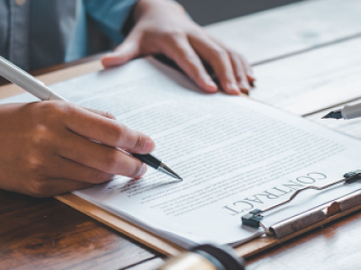 two people with pens in hands looking over a contract