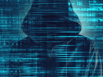 Cyber hacker wearing hoodie with code overlay