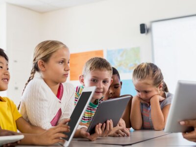 Teaching in a classroom of children teaching lessons using tablets that can gather evidence of learning.