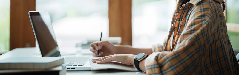 Graduate student writing at a desk