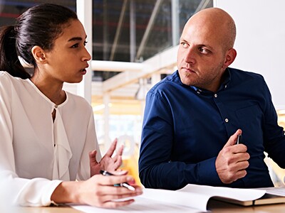 Two-Employees-Discuss-Workplace-Conflict