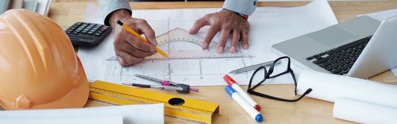 An engineer writing measurements on a piece of paper.