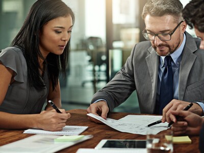 a diverse group of businesspeople reviewing documents in boardroom