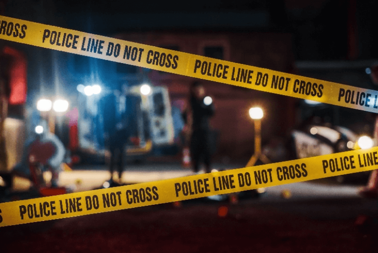 Police line tape across active crime scene including officers and lights
