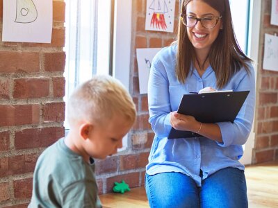 Female social work researcher observes a young boy's social behavior.