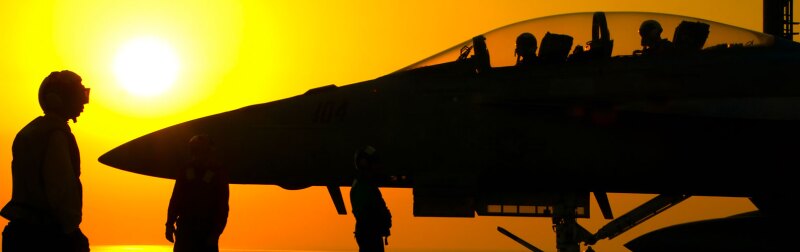 Silhouette of military personnel and a fighter jet against a vibrant sunset, representing aviation and military operations.