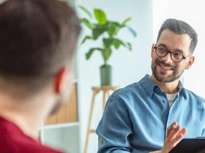 A counselor listens to his clients with an encouraging smile