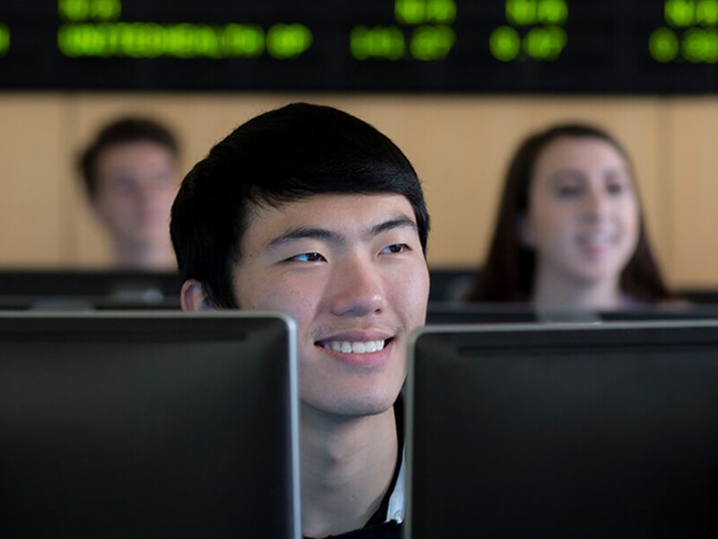 Male student looking over monitors in a classroom